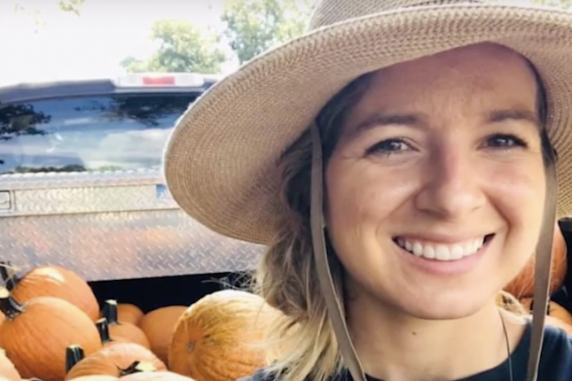 Photo of Krystle Owen in front of truck bed filled with pumpkins